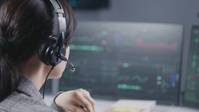 Close up of female financial analyst in headset working in broker agency office. Businesswoman looks at computer screen, monitors real-time stocks, exchange market charts. Cryptocurrency trading. - Powered by Shutterstock - Get 15% off with code: PIKWIZARD15