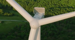 Early morning or late afternoon aerial drone view of wind power turbines under construction, on a green forest. Wind turbines are part of the energy transition strategy	