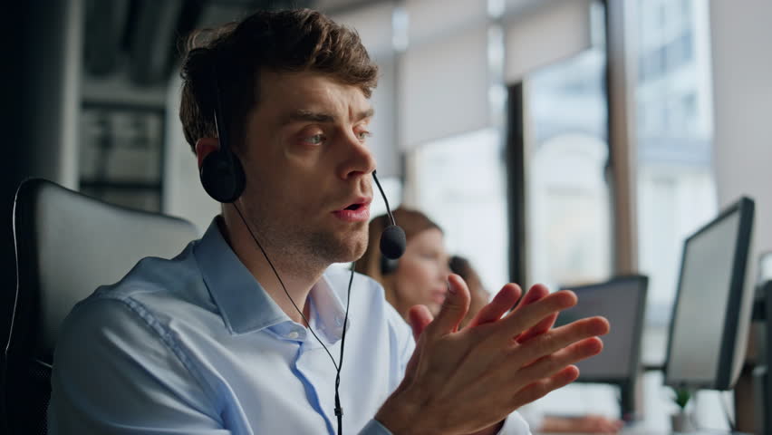 Closeup technical assistant talking in call center. Focused man listening client resolve request online. Thoughtful professional support agent work consulting customer in headset. Helpdesk job career Royalty-Free Stock Footage #1104643543
