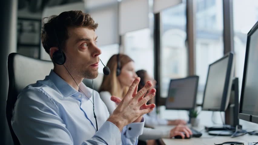 Technical support talk client in office. Pensive man specialist typing computer analyzing customer request on hotline. Serious confident agent operator helping consult in headset. Student career job Royalty-Free Stock Footage #1104643579