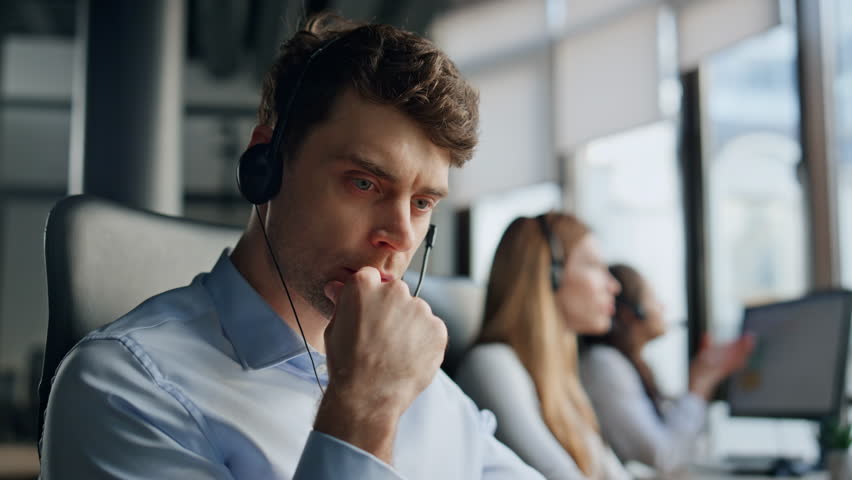 Thoughtful support agent listening customer at workplace. Focused man specialist helping client solving request on hotline. Serious professional manager work in data center. Helpdesk operator concept Royalty-Free Stock Footage #1104643661