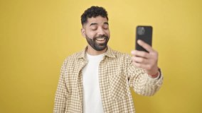 Young hispanic man smiling confident having video call over isolated yellow background