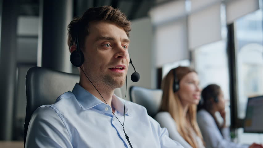 Smiling man working telemarketing center. Friendly man manager consult client in headphones. Professional support agent assistant talking typing keyboard helping customer. Hotline conversation concept Royalty-Free Stock Footage #1104650461