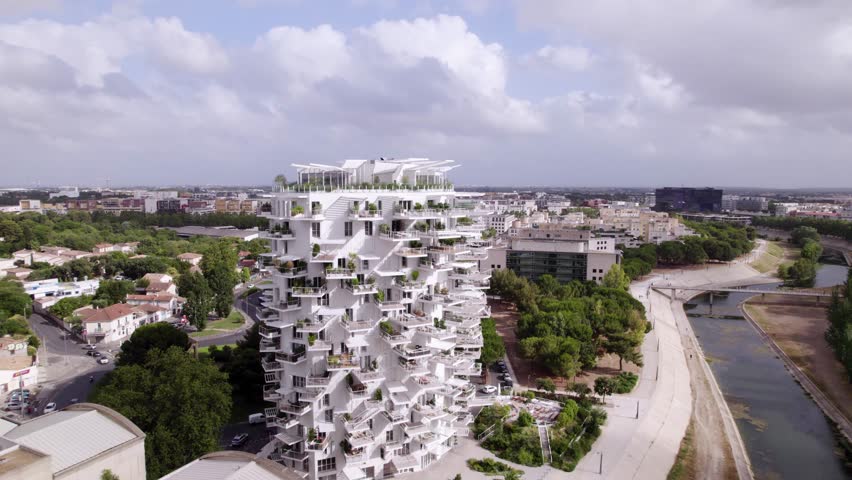 aerial drone view of the magnificent "Arbre Blanc", an emblematic building in the city of Montpellier in the south of France, with its large terraces, riverside, trees and other buildings all around