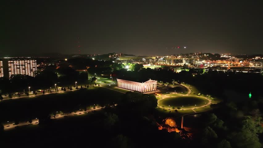 The Parthenon building at night in Nashville, Tennessee with drone video angled moving in wide.