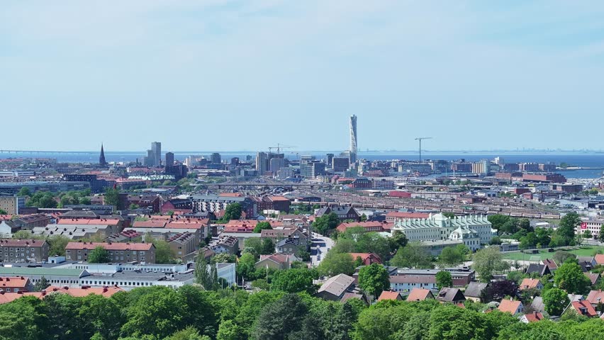 Wide angle aerial pan across malmo city skyline and suburbs on sunny day