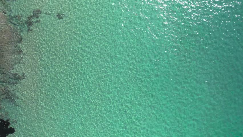 Drone 4K slow top view of three friends practising paddle surfing over cristal clear waters of the Mediterranean Sea in Spain