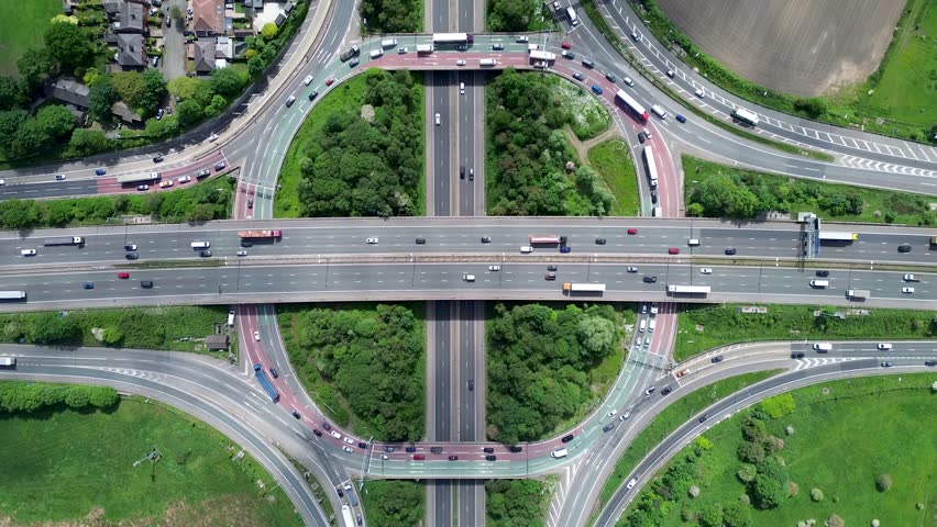 Aerial huge multi-lane circle roundabout intersection in city traffic highway. Public transport commuter pollution business concept Royalty-Free Stock Footage #1104662327