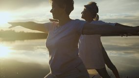 Group of senior woman doing yoga exercises by the lake. - Powered by Shutterstock - Get 15% off with code: PIKWIZARD15