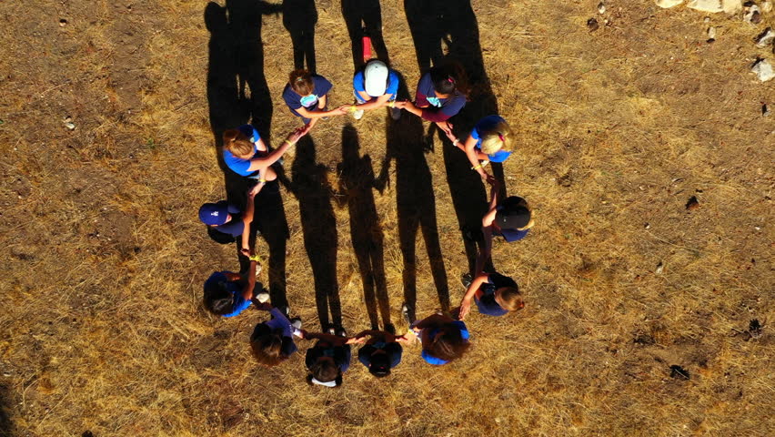 Aerial Top View Of Girls Making Huddle, Drone Ascending Over People - Big Bear, California