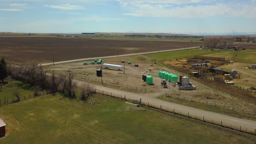 Farmers In Trailer Of Tractor Moving On Road At Countryside During Sunny Day - Billings, Montana