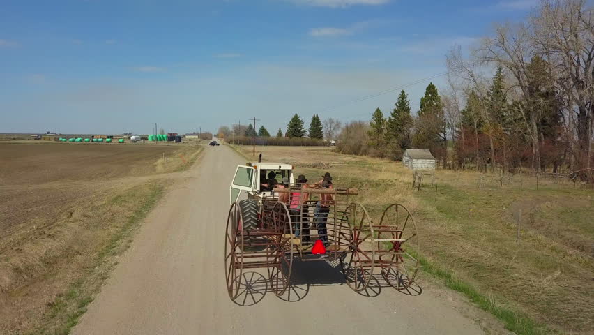 Tilt Down Shot Of Farmers Traveling In Tractor At Countryside On Sunny Day - Billings, Montana