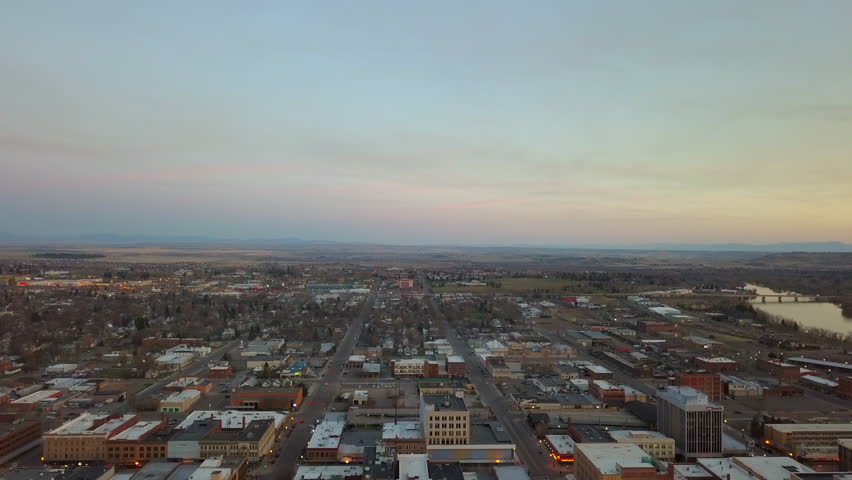 Aerial Backward Shot Of Buildings And Streets In City Against Sky During Sunset - Billings, Montana