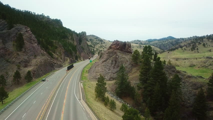 Aerial Backward Shot Of Empty Road By Mountain Against Sky - Billings, Montana