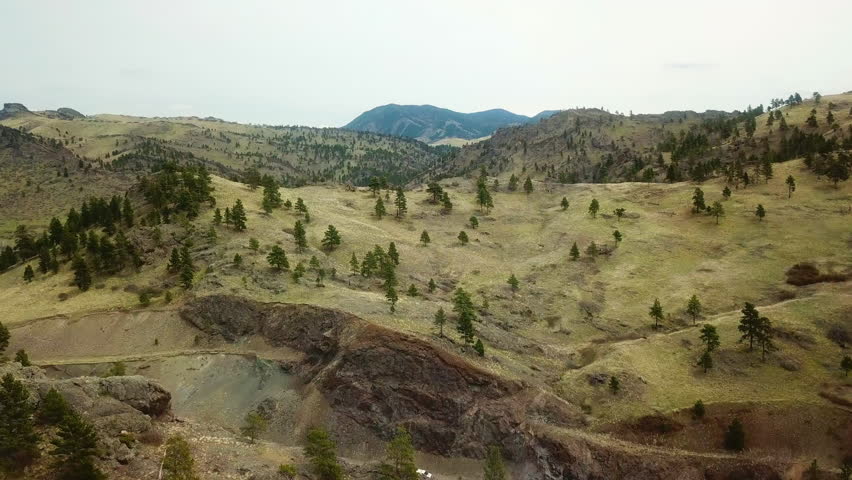 Aerial Tilt Down Shot Of Vehicles Moving On Road Amidst Mountain - Billings, Montana