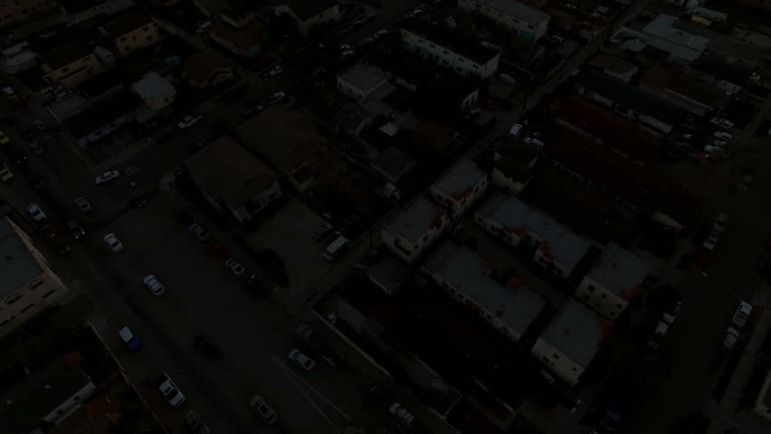 Aerial Tilt Up Shot Of Houses In Suburb Against Orange Sky, Drone Flying Backward Over City At Sunset - Long Beach, California
