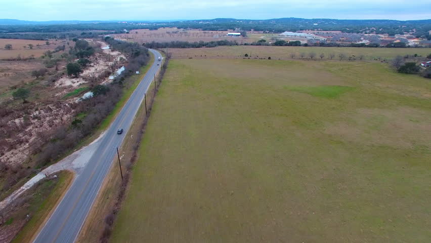 Aerial Shot Of Vehicles On Road By Green Field Against Sky, Drone Flying Forward Over Landscape - San Antonio, Texas