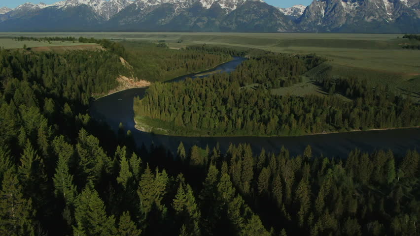 Aerial Cinematic Drone Jackson Hole Grand iconic Tetons Wyoming Snake River Spring greenery with snow capped mountain peaks vista point outlook turn out blue sky morning slowly pan up forward movement Royalty-Free Stock Footage #1104677685