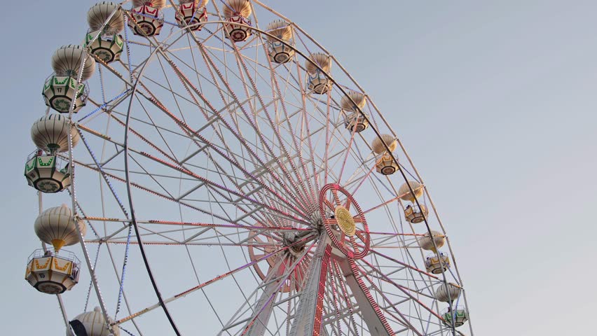 Ferris Wheel Swing in Amusement Park - Daytime Fun and Entertainment at Carnival or Theme Park. Perfect for Travel, Tourism, and Family Holiday Footage Royalty-Free Stock Footage #1104678727
