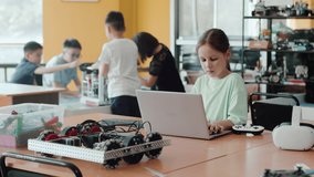 Girl programming the robot. Group of schoolchildren interacting using gadgets laptops for programming at robotics engineering class. School classroom of futuristic technologies - Powered by Shutterstock - Get 15% off with code: PIKWIZARD15