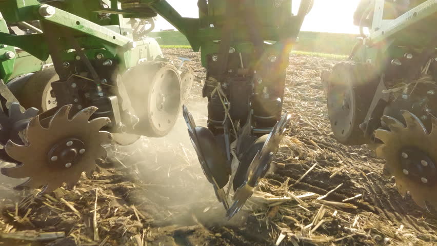 Close up on row cleaner disks of a strip till machine clearing residue while tilling farm land