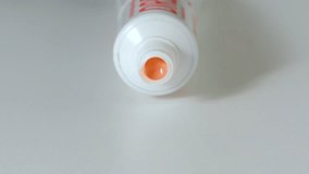 Pink toothpaste is squeezed from tube - Front View