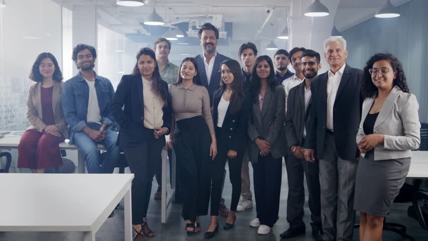A happy confident Asian Indian group or team of diverse male and female corporate office executive colleagues together posing and looking at the camera smiling in a modern start up business workspace  Royalty-Free Stock Footage #1104686879