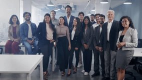 A happy confident Asian Indian group or team of diverse male and female corporate office executive colleagues together posing and looking at the camera smiling in a modern start up business workspace  - Powered by Shutterstock - Get 15% off with code: PIKWIZARD15