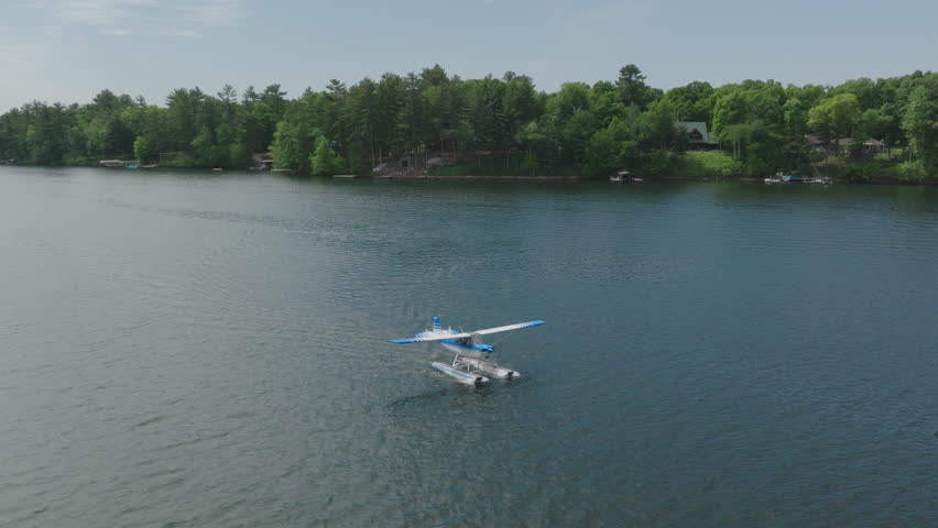 Aerial of a seaplane floating in the middle of a lake on a clear summer day