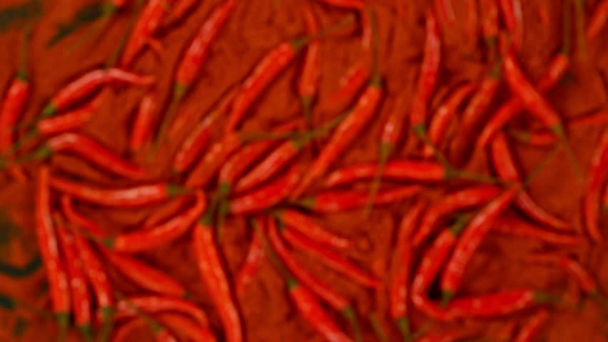 Super slow motion of flying and rotating red chilli peppers. Filmed on high speed cinema camera, 1000 fps, placed on high speed cine bot, following the target. Black background. Speed ramp effect. Royalty-Free Stock Footage #1104688397