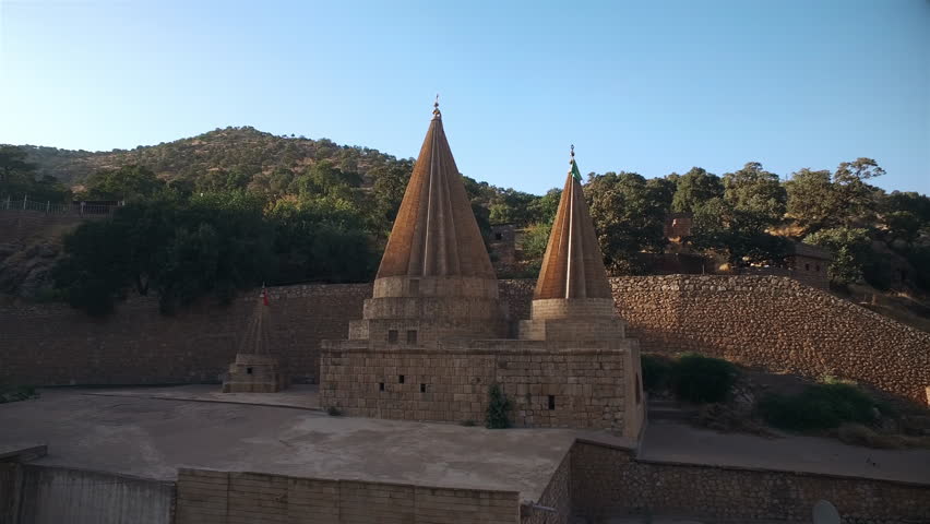 Temple of Yazidi Religion (Lalish – The Ziarat) 4K The Yazidi temple at Lalish is a potent reminder of human faith’s ability to persevere. This ancient holy site is where all Yazidi people assemble to Royalty-Free Stock Footage #1104688399