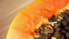 In a probe lens macro video, a vibrant half papaya reveals intricate details, textures, and colors, captivating viewers in its tropical allure. Macro and fruit concept. Shot with laowa 24mm probe lens
