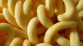 In a macro video, a probe lens reveals the intricate details of block-shaped instant noodles, showcasing their texture, composition, and form in captivating close-up shots. Slide dolly shot. 4K
