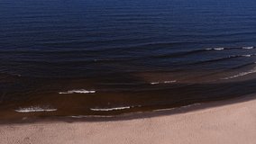 Drone aerial view of waves sea ocean coast. Beach and dunes dark calm sea waves nature landscape captured with drone. Tourism
