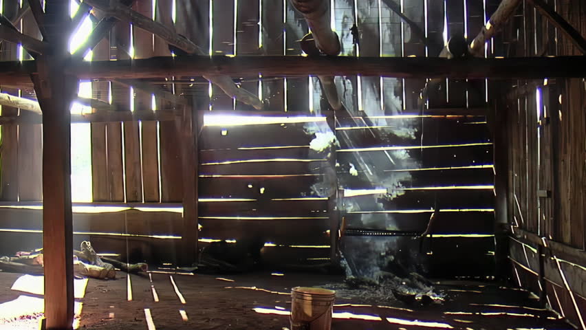 Smoke Against Old Weather-beaten Wooden Slats on a Traditional Tobacco Barn While the Tobacco is Being Fire-cured. Royalty-Free Stock Footage #1104695971