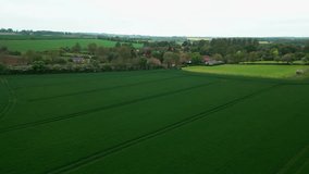 Serene Brinkhill village, UK, captured in cinematic aerial video. Red tiled rooftops, brick and thatched houses, and scenic rural farmlands on display.