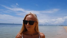 beautiful blonde woman in sunglasses spending time on the beach 