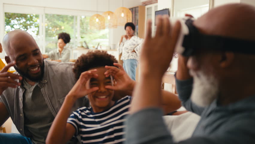 Grandfather wearing VR headset is amazed as he sits with multi-generation male family on sofa at home together - shot in slow motion | Shutterstock HD Video #1104705499