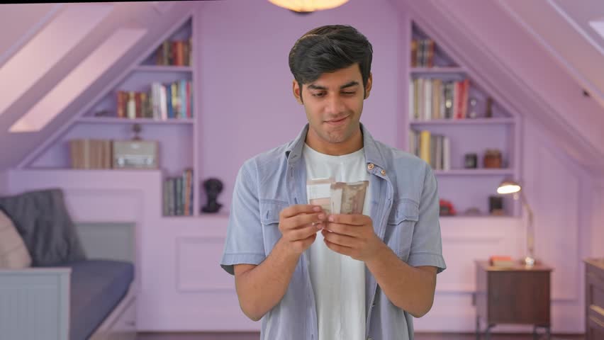 Happy Indian young man counting money