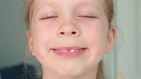 Facial gymnastics for the mouth. A wide smile and lips curled into a tube. Speech staging by a speech pathologist and speech pathologist. Warming up the muscles of the mouth