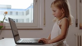 Child girl raising hands emotionally looking at laptop
