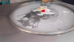 Close-up on a Stir-fried ice cream being prepared on an ice pan. Also known as rolled ice cream, it is a sweetened frozen dessert from Thailand.