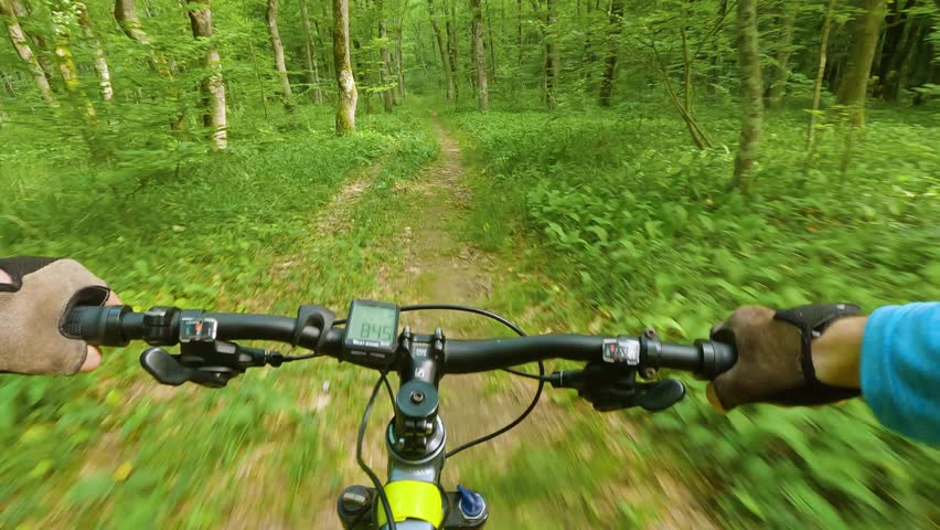 Extreme sport of mountain biking in the forest. First-person view. A man cycling down a path in the countryside. POV. Outdoor cycling Leisure activities sport recreation activity extreme Royalty-Free Stock Footage #1104722685
