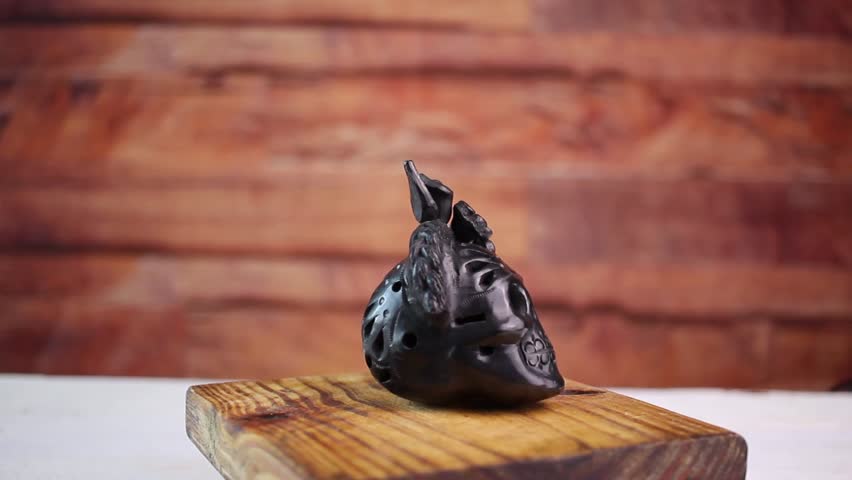 Mexican crafts from Oaxaca, made of black clay, in the shape of a skull. catrina . spinning slow Royalty-Free Stock Footage #1104728445