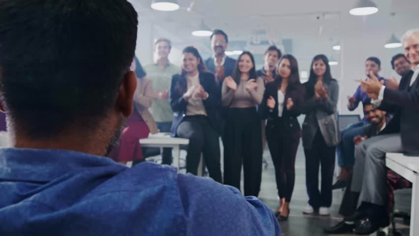 A group of happy office colleagues or team members celebrating the success and achievement of an Indian Asian handicapped or physically disabled man sitting in a wheelchair in a corporate start up Royalty-Free Stock Footage #1104735881