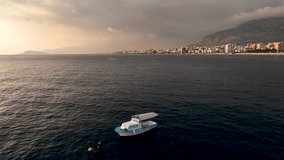 Serene Maritime Spectacle: Cinematic Drone Captures Fisherman's Boat and Underwater Fishing Against the Majestic Mediterranean Sunset