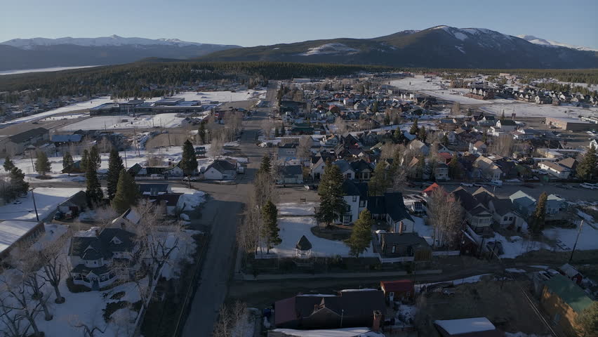 Leadville Aerial cinematic drone Colorado historic downtown winter spring snowy street buildings late afternoon early evening blue sky bright sunshine forward pan up reveal movement