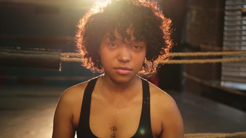 Outcry independent girl power. Angry african american woman fighter with boxing gloves looking serious aggressive to camera standing on boxing ring. Strong powerful girl looking concentrated straight Royalty-Free Stock Footage #1104742075