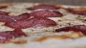 Pizza salami, ham, cheese and black pepper with spices. Freshly baked salami ham pizza with cheese. Spins beautifully. Video clip. Pizza smiley.