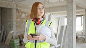 Young blonde woman architect using smartphone holding hardhat at construction site - Powered by Shutterstock - Get 15% off with code: PIKWIZARD15